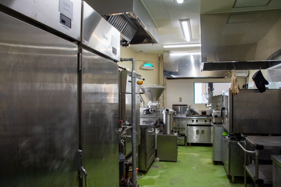 魚久精肉総本店の加工場内観（冷蔵庫・充填機・オーブンの製造ライン）